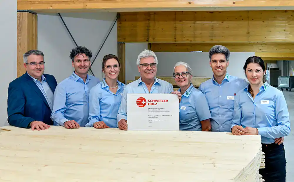 7 membres de la famille Ruch, propriétaire de Woodwork AG, devant un tas de bois