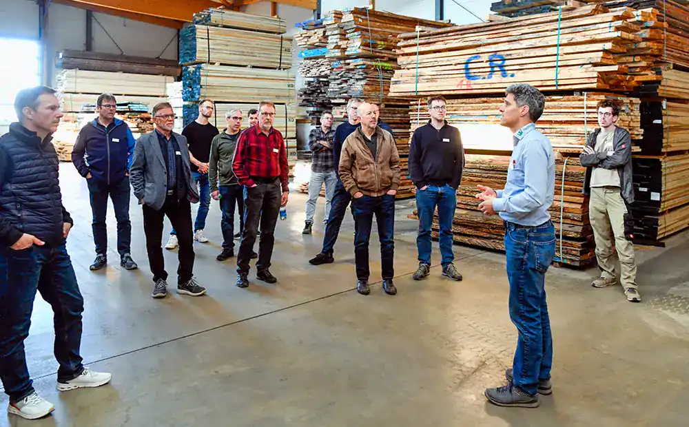 Eine Gruppe von Männern lauscht der Präsentation von Christoph Ruch in der Woodwork Neubauhalle