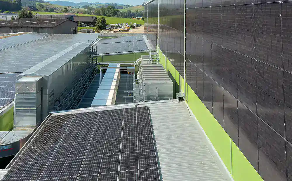 Blick auf 12 Batteriespeicher und an Dach- und Fassaden installierte Solarpanels