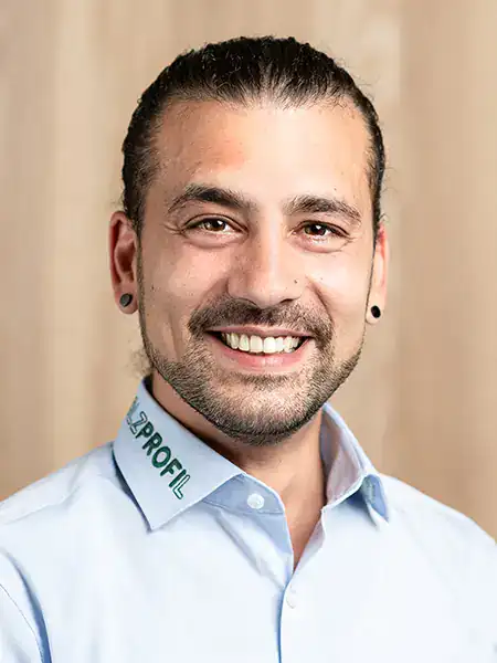 Portrait eines freundlich lächelnden Mannes mit Dreitagebart und schwarzen Ohrsteckern